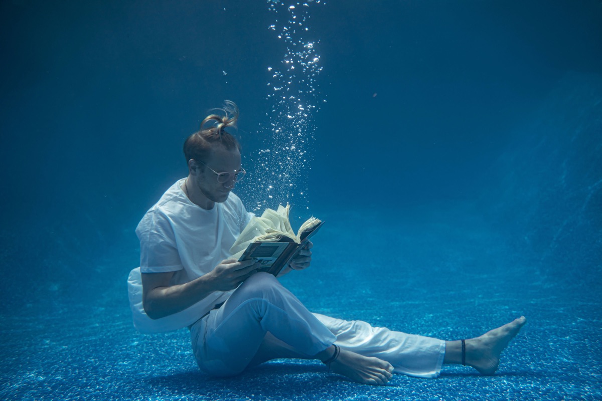 Underwater dancer floating in blue water during a private SubMergence session